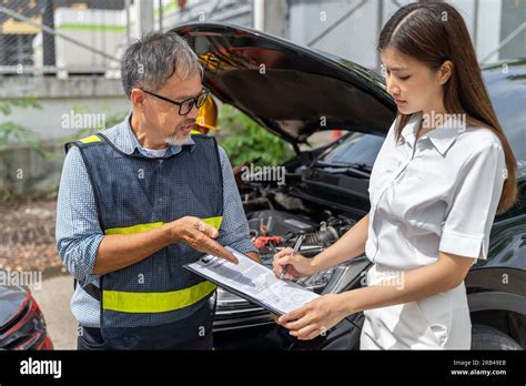 A Car Insurance Agent Showing The Woman Customer Where To Sign The Car A Car Insurance Agent Showing The Woman Customer Where To Sign The Car
