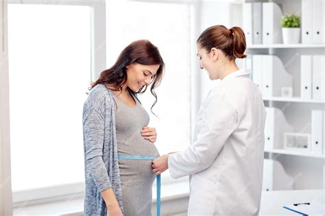 Gynecologist Doctor Measures With Centimeter Tape Of A Pregnant Woman Gynecologist Doctor Measures With Centimeter Tape Of A Pregnant Woman